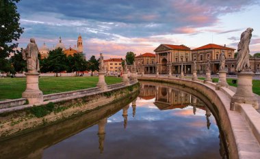 Canal of Prato della Valle square at sunset, Padua, Veneto, Italy. Picturesque burning clouds reflected in the water