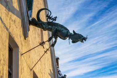 Dragon of Rus Magistrate (Town Hall) - stylized drainpipe against picturesque sky. Old city of Kamianets-Podilskyi, Ukraine at sunny winter day