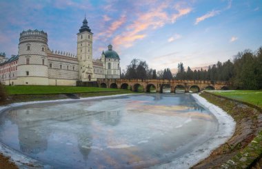 Krasiczyn 'deki Rönesans Kalesi' nin manzarası Przemysl yakınlarında kış akşamları, Podkarpackie Voyvodeship, Polonya. Kale, savunma hendeğinin donmuş sularına yansıdı.