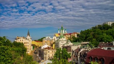 Scenic view to Andrew's church, Andriivsky descent, Richard the Lionheart House and historic buildings in the center Kyiv, Ukraine. Motion of clouds, crowded street. 4k time lapse