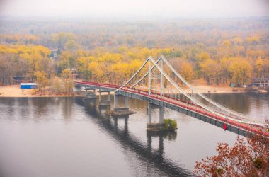 Ukrayna 'nın başkenti Kyiv' de yaya parkı köprüsü, Trukhaniv adası ve Dinyeper nehri ile sonbahar manzarası..