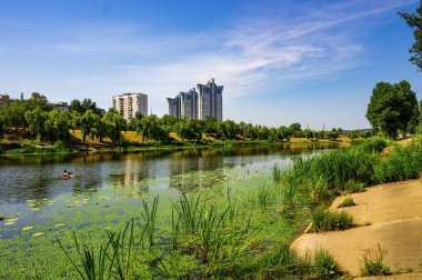On the bank of artificial canal in Rusanivka district, Kyiv, Ukraine. Modern residential buildings on background.