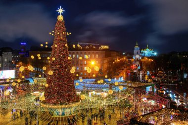 Ukrayna 'nın Kyiv kentindeki Sofya Meydanı' nda aydınlatılmış Noel ağacı, şenlikli süsleme ve Noel pazarı. Arka planda St. Michael 's Altın Kubbe Manastırı