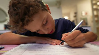 Sınava çalışan çocuk evde ödev yapıyor.