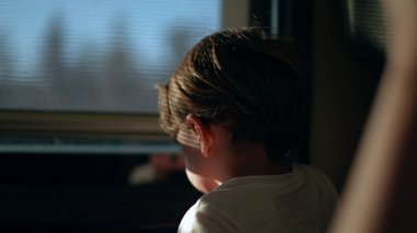 Küçük çocuk tren penceresini kapatıyor, çocuk demiryolu ile seyahat ediyor.