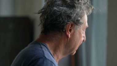 Pencere kenarında durup dışarıyı izleyen dalgın kıdemli bir adam. Düşünceli yaşlı adam.
