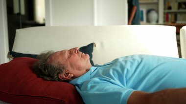 Yaşlı adam kanepede dinleniyor. Son sınıf öğrencisi uyuyor.