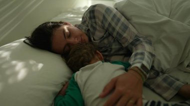 Anne ve çocuk sabahları yatakta birbirlerine sarılıyorlar.