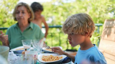 Dışarıda yemek yiyen aile, yemek sırasında bir araya gelir.