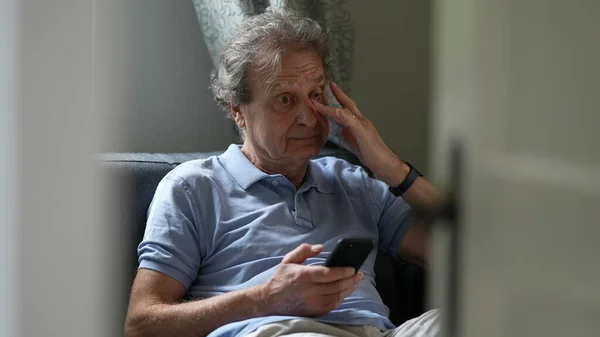 Pensive Senior Man Sitting Sofa Looking Cellphone Device Person Scratching — Stockfoto