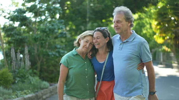 Neşeli kız, yeşil şehirde yaşlı ailesiyle birlikte gülüyor ve gülüyor.