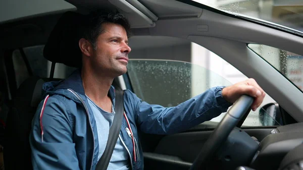 Happy driver holding steering wheel driving in city