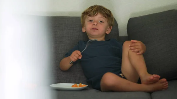 Enfant Mangeant Melon Collation Fruits Assis Sur Canapé Maison — Photo