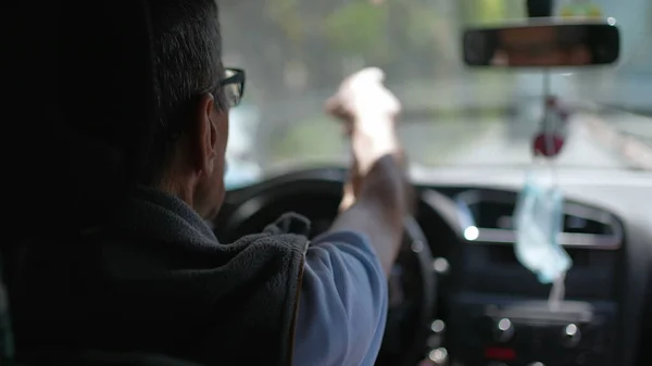 Back of older man driving on road. Senior driver on trip