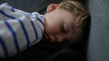 Çocuk öğleden sonra kanepede kestiriyor.