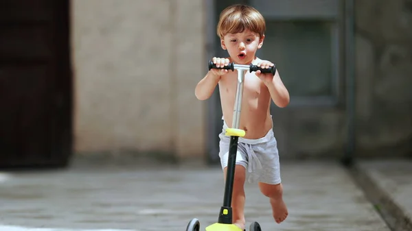 Child Riding Three Wheeled Scooter Shirtless — Foto de Stock