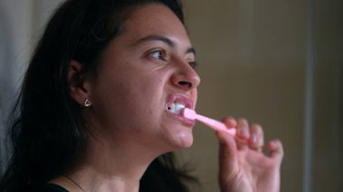 Geceleri dişlerini fırçalayan kadın.