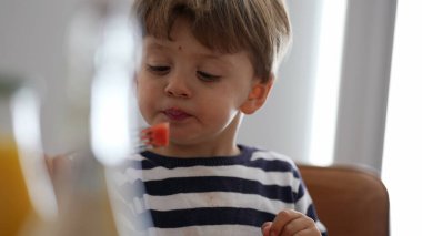 Evde meyve atıştırmalığı yiyen gizli bir çocuk.