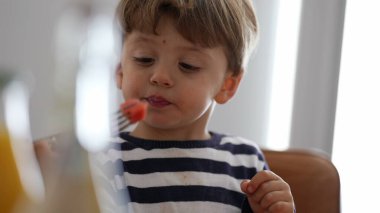 Evde meyve atıştırmalığı yiyen gizli bir çocuk.