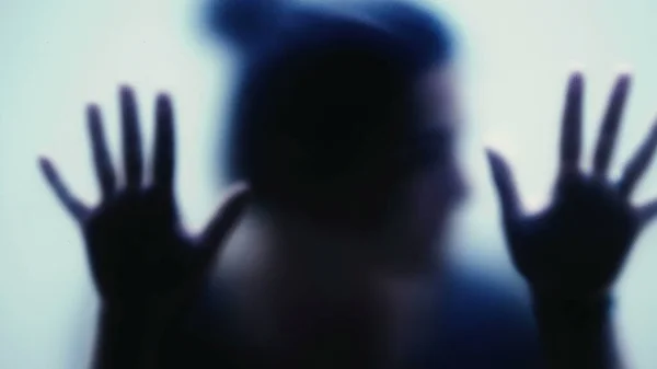 Camın arkasına sıkışmış depresyon konseptini destekleyen ve yardım isteyen depresyonlu bir kadın.