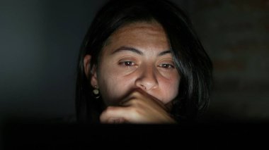 Gece yarısı bilgisayar ekranı önünde metin okuyan kadın