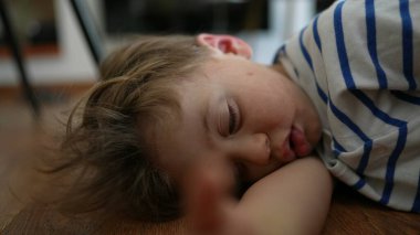 Üzgün çocuk, gözleri yuvarlanıyor, can sıkıntısı içinde evde yatıyor, yapacak bir şey yok.