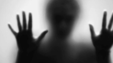 Camın arkasındaki ürkütücü kişi, korku ve depresyon konseptine takılmış korkunç insan, tek renk.