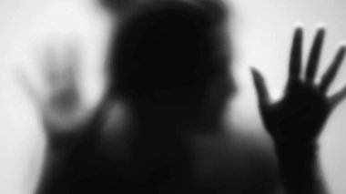 Camın arkasındaki ürkütücü kişi, korku ve depresyon konseptine takılmış korkunç insan, tek renk.