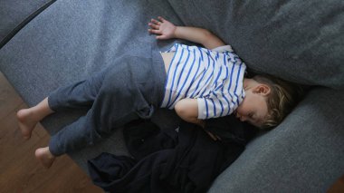 Küçük çocuk kanepede kestiriyor çocuk kanepede uyuyor