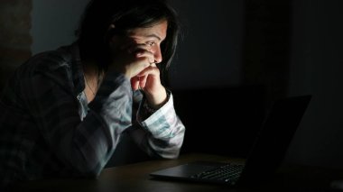 Geceleri dizüstü bilgisayarın önünde içeriği okuyan kişi
