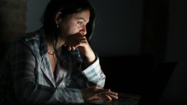 Geceleri dizüstü bilgisayarın önünde içeriği okuyan kişi