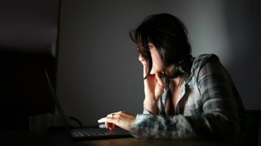 Gece bilgisayar ekranına bakan kişi internette geziniyor