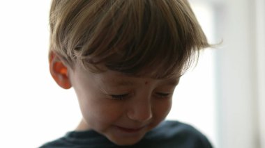 Sevimli, şapşal bir çocuğun gözleri kapalı. Sevimli bir çocuk gözlerini açıyor.