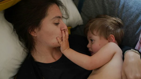 엄마가 걸음마를 아기에게 입맞추는 엄마는 장난기가 아기에게 키스한다 — 스톡 사진