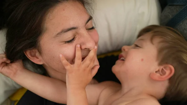 엄마가 걸음마를 아기에게 입맞추는 엄마는 장난기가 아기에게 키스한다 — 스톡 사진