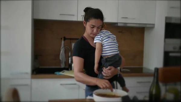 Moeder Koken Terwijl Het Houden Van Baby Peuter Kind — Stockfoto