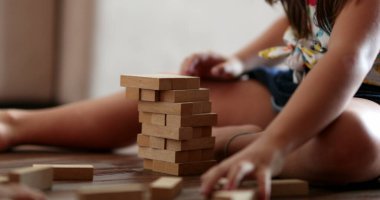 Kardeş, kardeş yapıtaşlarını yıkıyor. Küçük kız blokları koruyor