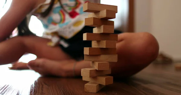 Child playing with wooden building blocks. Kid trial and error play