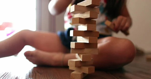 Child playing with wooden building blocks. Kid trial and error play