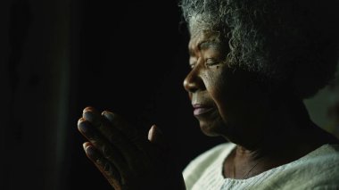 Yaşlı bir kadın Tanrı 'ya dua ediyor. Yaşlı bir Afrikalı dua ediyor.