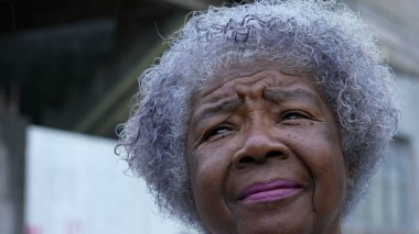 Düşünceli yaşlı bir kadın gökyüzüne bakıyor fırtınanın yaklaştığını hissediyor.