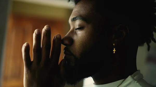 A spiritual black man praying with hands together