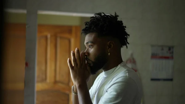 A religious black man praying to God with seeking divine help