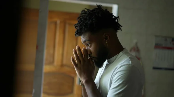 A religious black man praying to God with seeking divine help