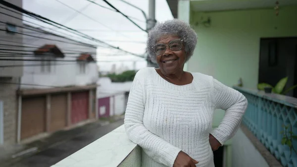 A black senior woman portrait standing outside smiling at camera