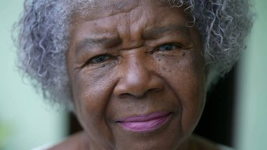 Kameraya bakan yaşlı siyah bir kadının portresi.