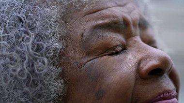 Düşünce ve meditasyonda gözlerini kapatan Afrikalı bir kadın.