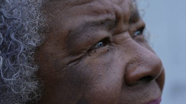 Afrikalı yaşlı bir kadın UMUT ve FAITH makro gözleriyle gökyüzüne bakıyor.