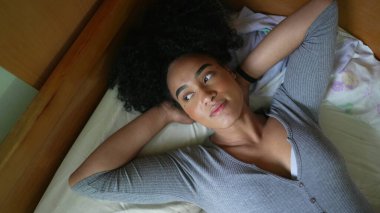 Yorgun bir kadın yatakta uzanıyor. Huzurlu bir anda bir insanı dinlendiriyor.