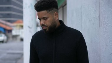 Düşünceli bir siyah adam şehir sokağında dikiliyor düşünceli bir insan